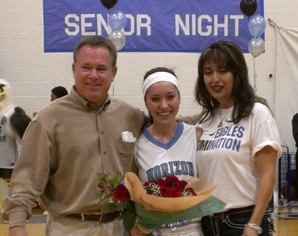 Senior Gina Garvey poses with her parents before the Valley Christian game.