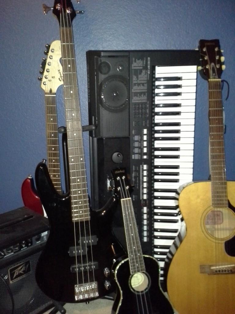 All of Evan Rossers instruments, including an electric bass, ukulele, acoustic guitar, electric guitar, and keyboard.