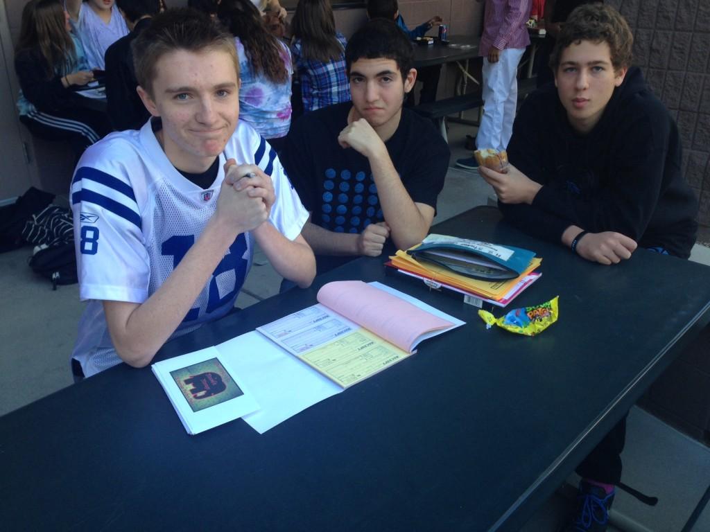 Juniors Patrick McPherson, Jonathan Elias, and Charles Jamison sit at the Homecoming ticket table. The tickets were sold at $25 for singles and $40 for couples this week.
