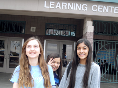 Eighth graders Ella Coste and Roshi Patel pose in front of the Learning Center while being photobombed by seventh grader Jessica Espinoza. All three girls plan to continue at Horizon Honors for high school. 
