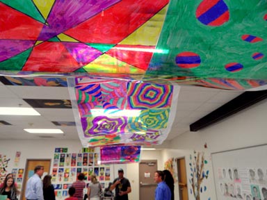 Students and their families stand under a colorful laminated 
sheet made by Intro to Art students. This project was created 
using sharpies and transparencies.