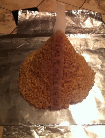 13. Place the message you wrote on parchment paper on the Hershey’s Kiss shaped Rice Krispie treat, letting it hang off the top a little.