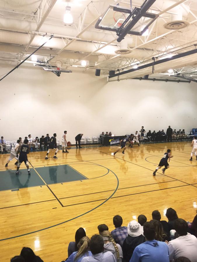 The Boy Varsity Basketball team follows the ball down court. 