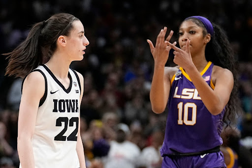 Angel Reese gestures at Caitlin Clark on the court.