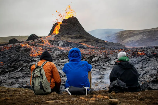 Tourists sitting next to an Iceland volcano that has already erupted.