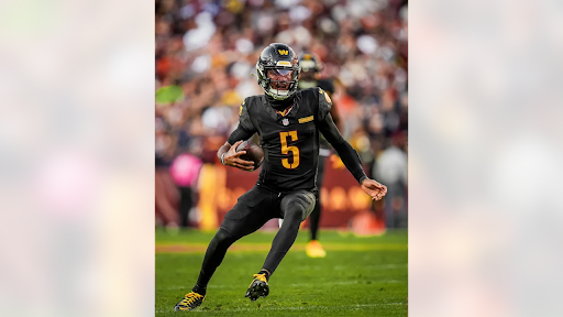 Quarterback Jayden Daniels runs the ball during a game against the Chicago Bears.