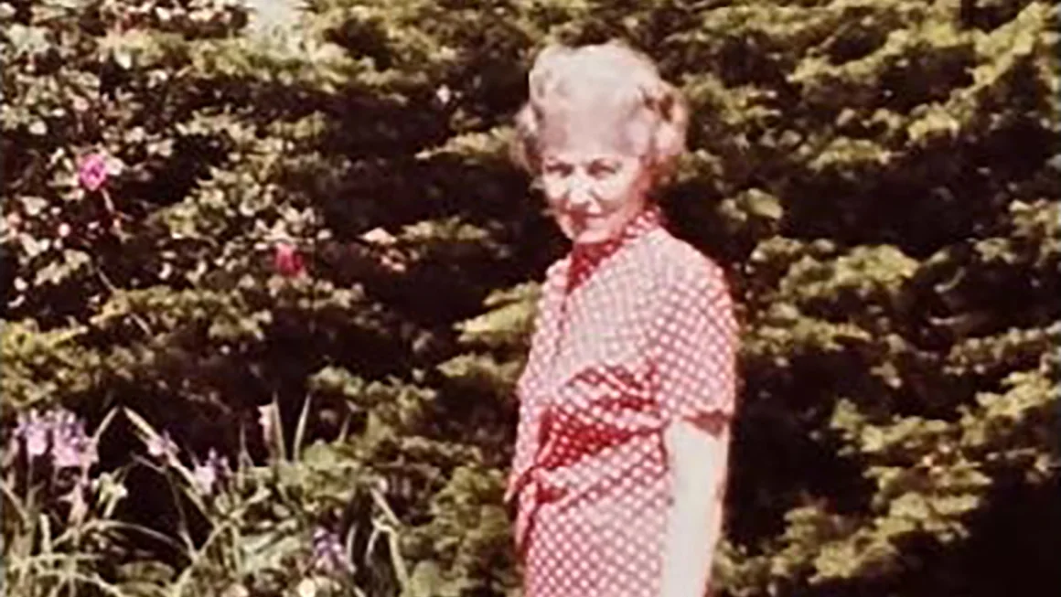 Edna Schubert in her backyard smiling. 