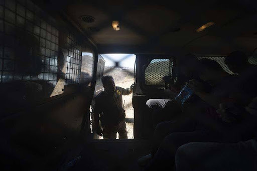 A border control agent in San Diego speaks to four detained immigrants who illegally crossed from Mexico.