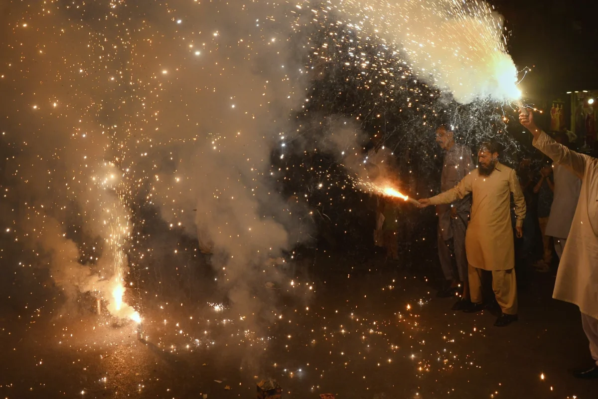 People lighting fireworks in celebration of India and Pakistan ceasefire.