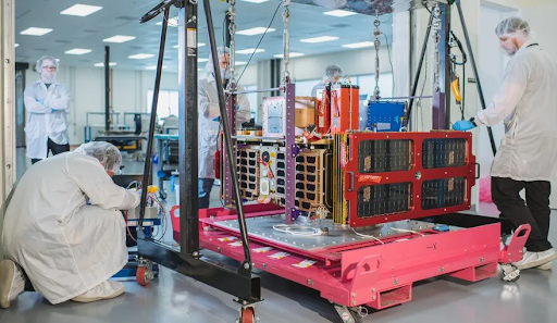 Picture of Momentus workers cleaning the payloads for the Vigoride rocket.