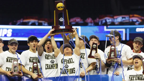Image of Asher Hong holding the NCAA trophy, with his team